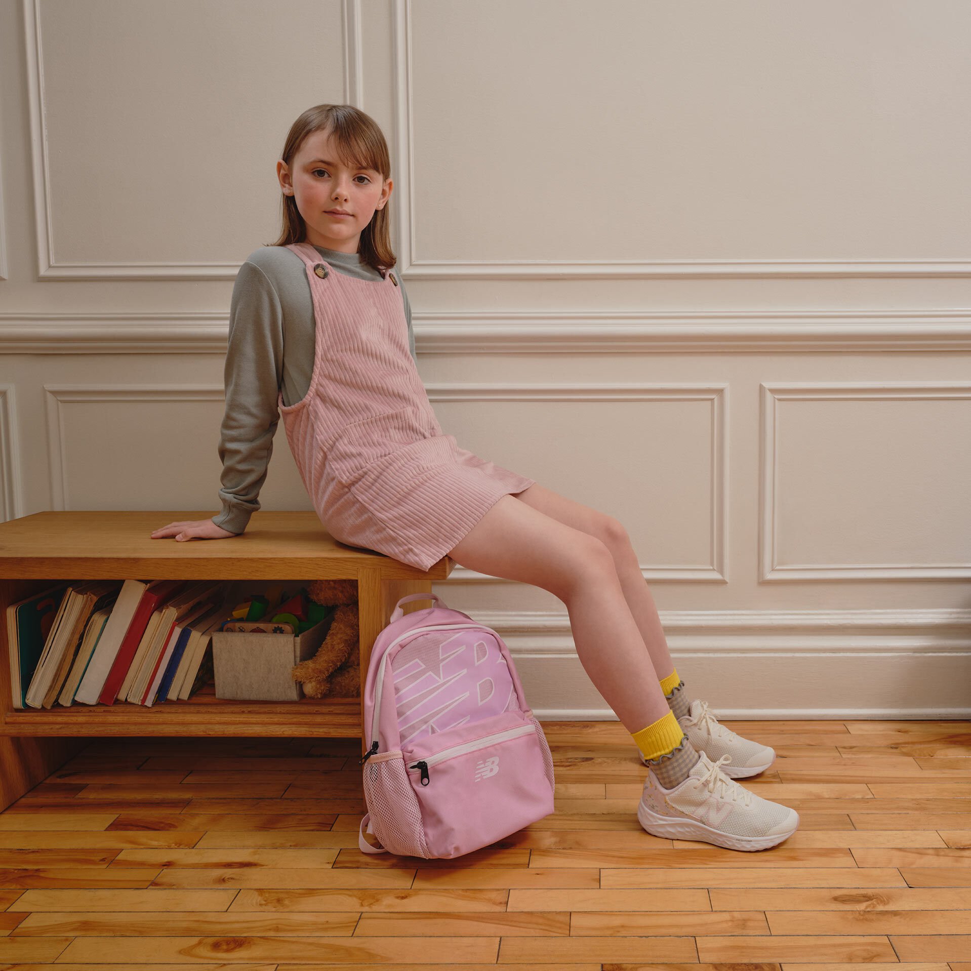 Girl wearing gray New Balance shoes.