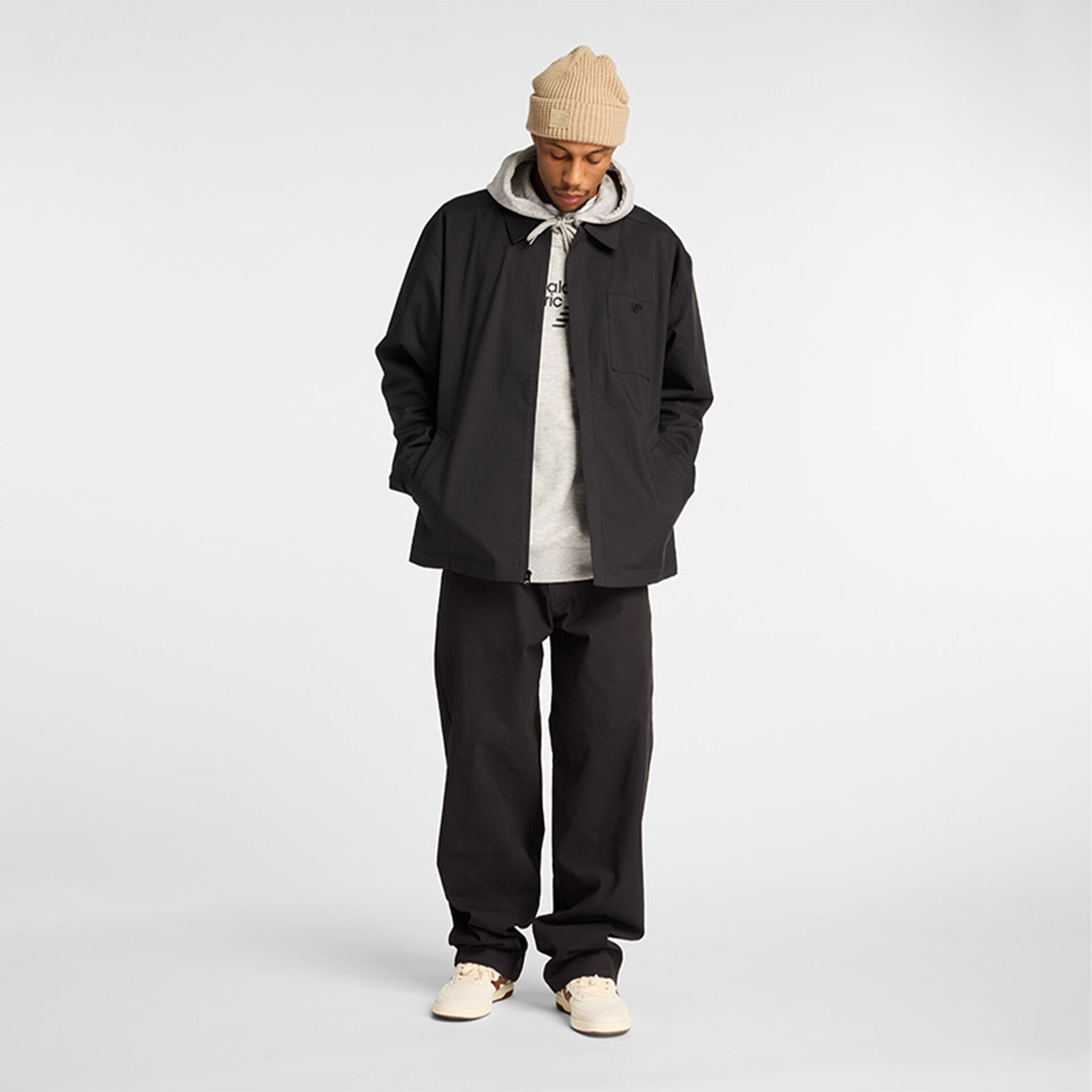 Man in New Balance black jacket and pants.