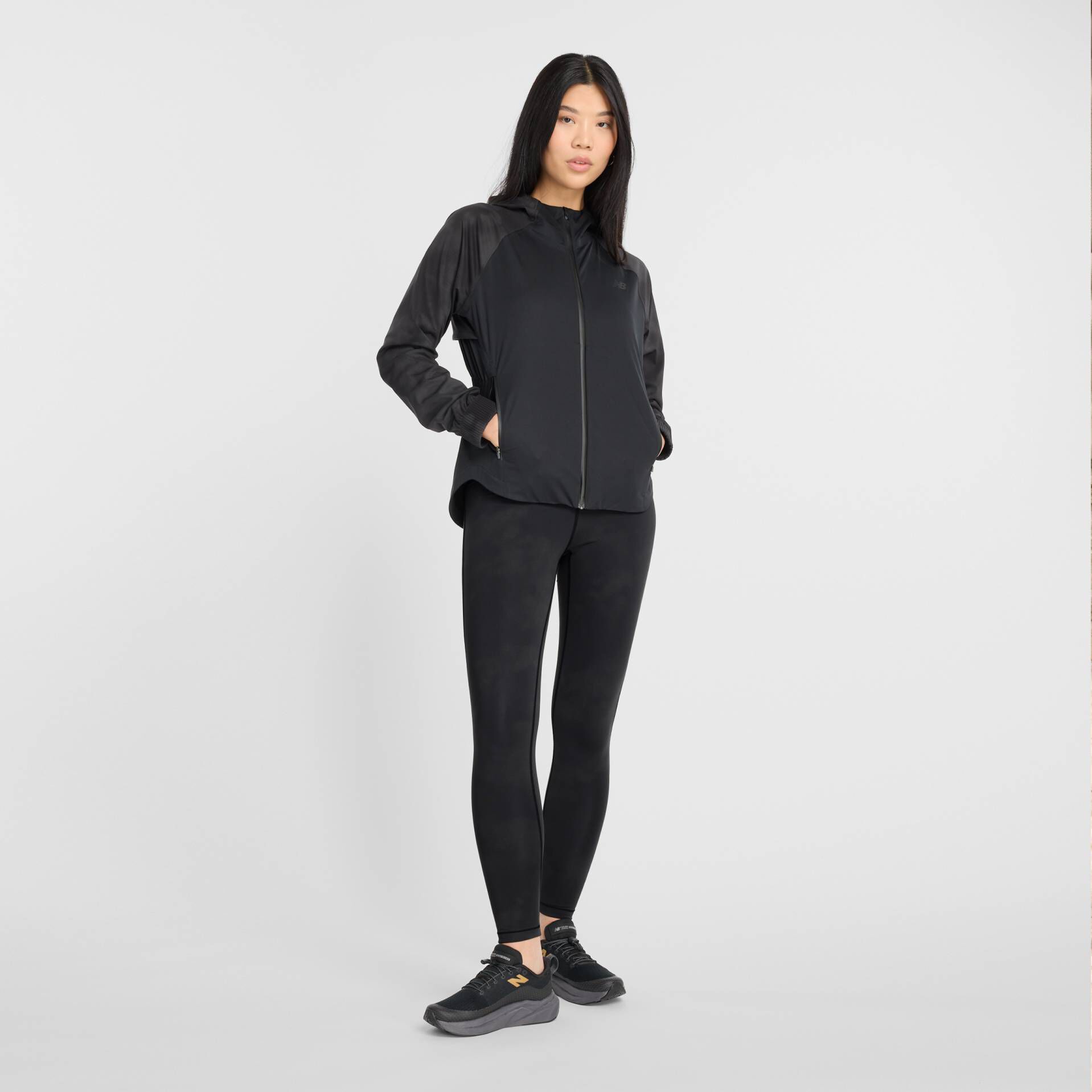 Woman in black New Balance jacket and leggings.